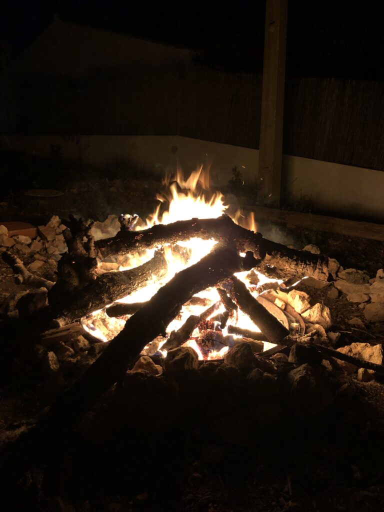 large fire in a cozy outdoor fire pit at a private psilocybin session, Algarve Portugal